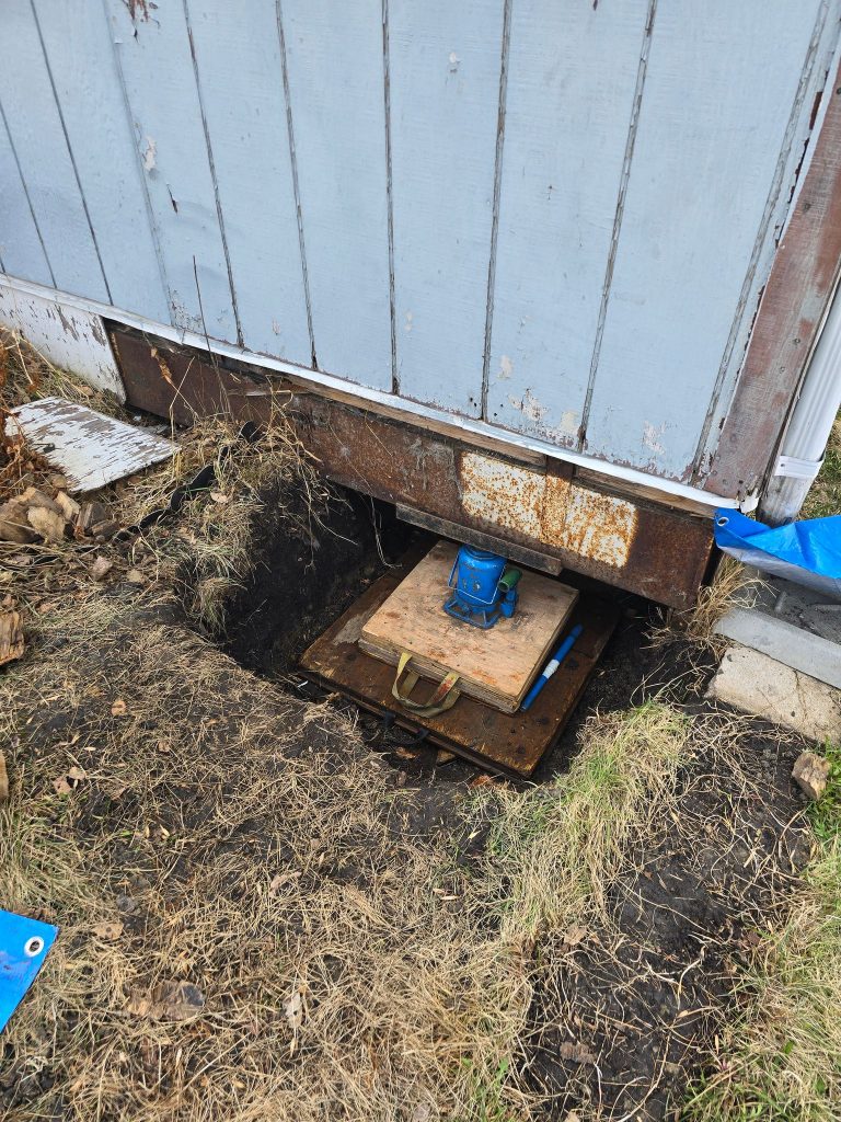 Mobile home levelling jack in position to lift home in Edmonton